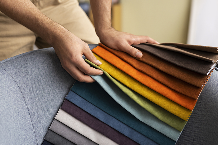 Person choosing fabric samples for sofa reupholster