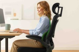 Woman sitting on an ergonomic office chair with proper posture while working at a desk