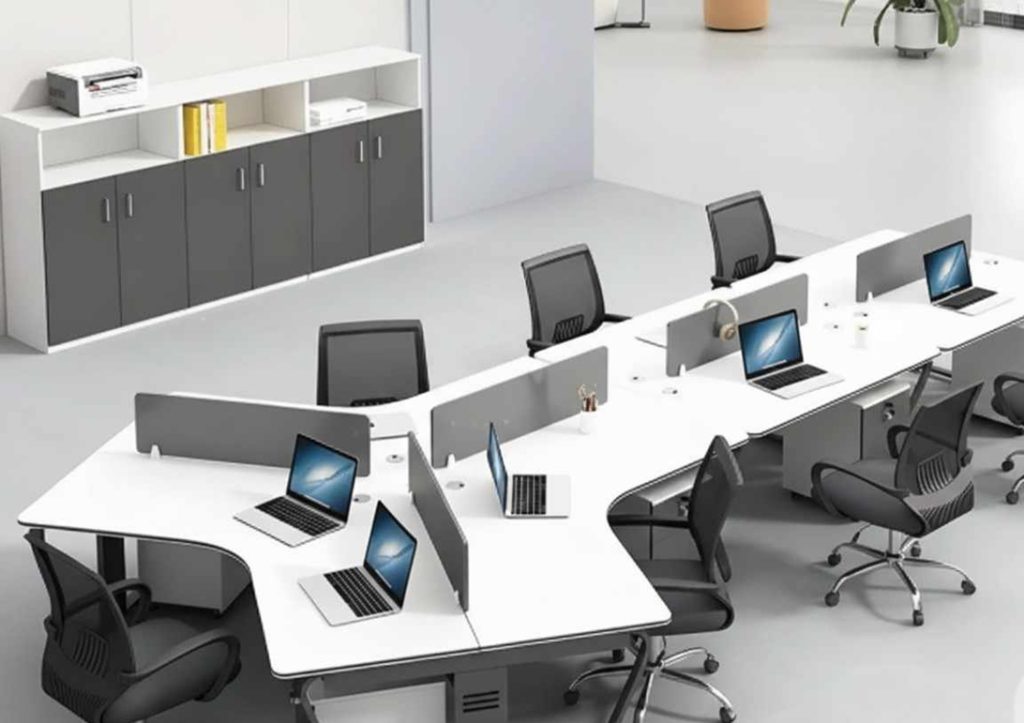 Modern open-plan office setup with white workstations, ergonomic chairs, laptops, and a storage cabinet in a clean, minimal workspace