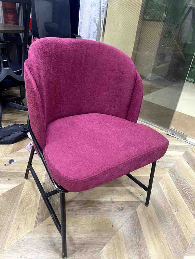 Pink upholstered dining chair with curved backrest and metal frame