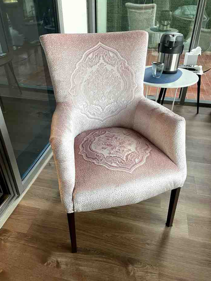 Fabric upholstered arm dining chair with patterned design and wooden legs