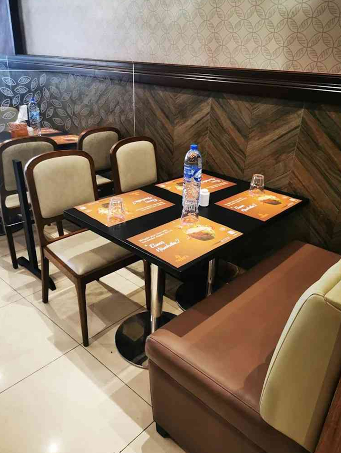 Restaurant dining chairs and booth seating with upholstered seats arranged around dining tables