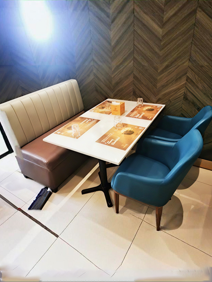 Restaurant booth seating with upholstered bench and blue dining chairs around a table