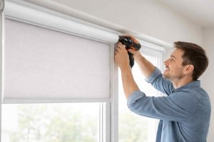 Professional roller blinds installation in Dubai showing technician fixing a window blind for smooth light and privacy control