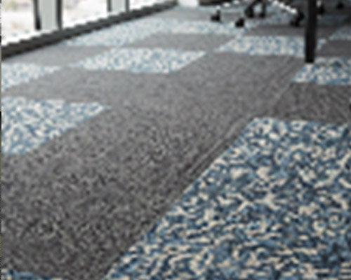 Cut and loop carpet tiles in office space with stylish mixed fiber pattern.
