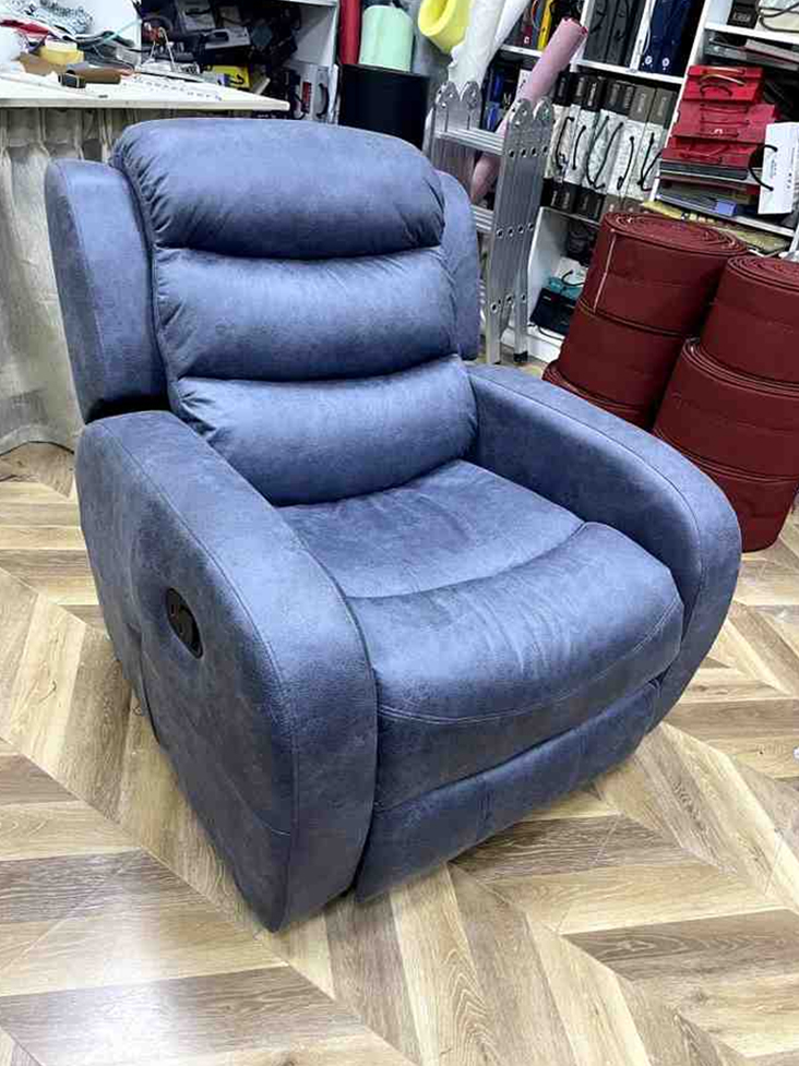 A blue recliner chair with a segmented backrest and wide armrests