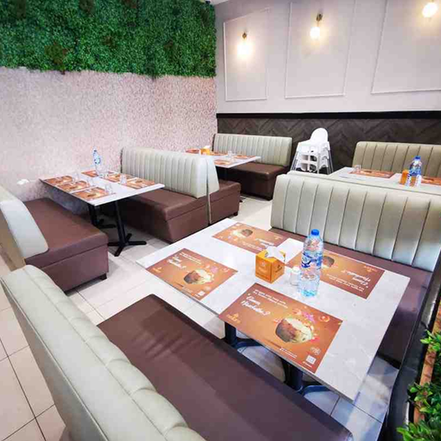 Modern custom made sofa booth seating arranged for cozy cafe dining space