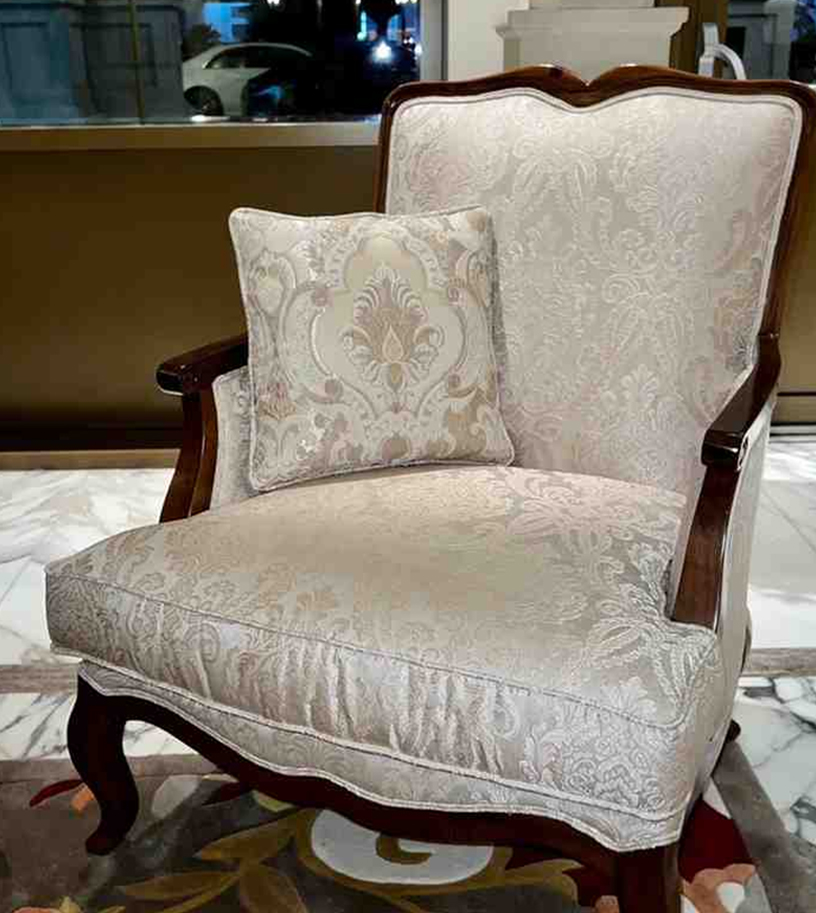 Classic wooden armchair with patterned fabric upholstery and cushion