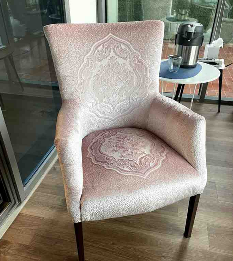 Upholstered armchair with patterned fabric and wooden legs