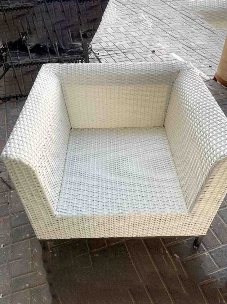 White wicker lounge chair with woven texture and boxy design