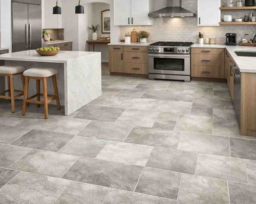 Modern kitchen with gray stone-look vinyl tile flooring and stylish cabinetry.