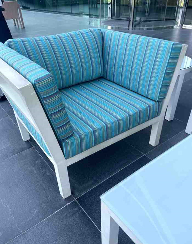 Outdoor armchair with striped upholstery and cushioned seat and backrest