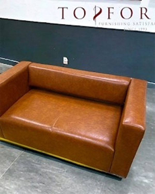 Brown leather office sofa with cushioned seating for reception or lounge areas